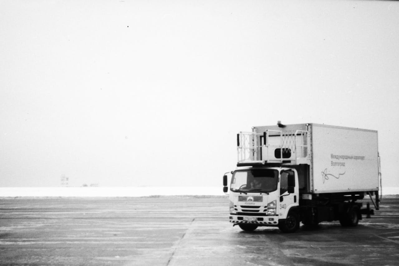 creative-03 Black and white image of a delivery truck on an empty expansive roadway.