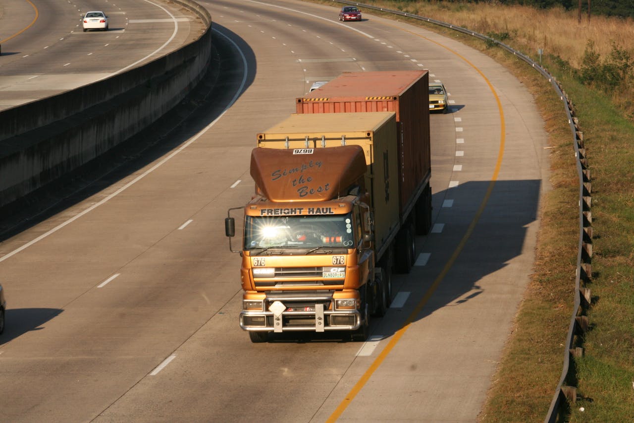 why-choose-us Cargo truck navigating a highway, aerial view on Dolphin Coast, South Africa.