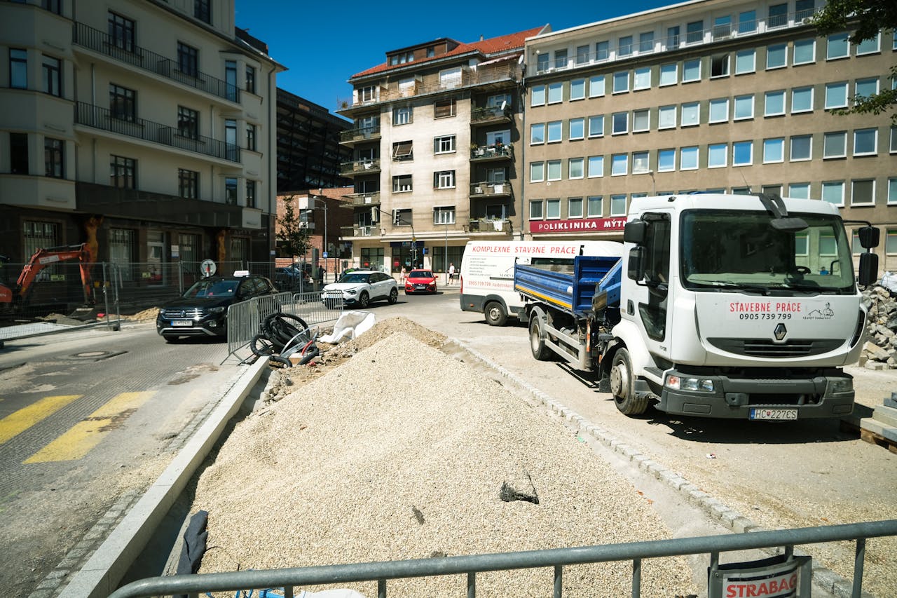 creative-02 Construction site in Bratislava with trucks and gravel, showcasing urban street renewal.