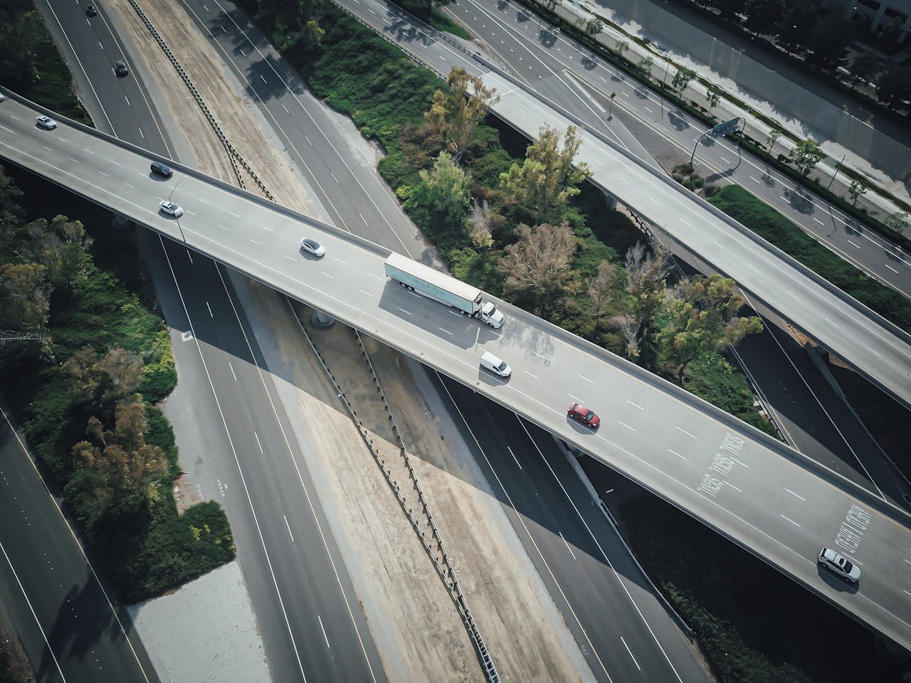 creative High-angle aerial shot of a highway intersection with various vehicles in motion.